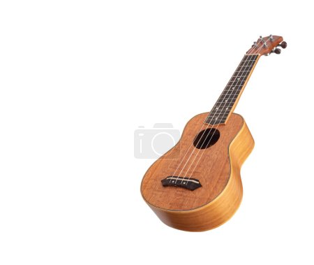 Guitarra Ukulele Hawaii sobre fondo blanco, mago de madera Okoume, enfoque selectivo
