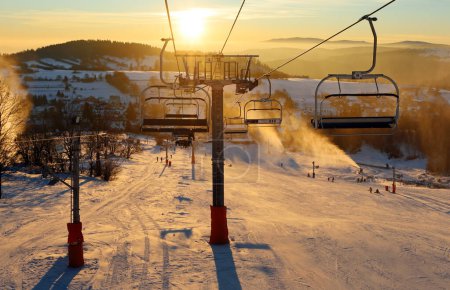 Téléchargez les photos : Ski resort, skiers on the ski lift, white snow pine trees at pink sunset or dawn, Krahule Slovakia - en image libre de droit