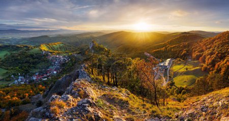 Téléchargez les photos : Montagnes au coucher du soleil en Slovaquie Vrsatec. Paysage avec collines de montagne orangers et herbe à l'automne, ciel coloré avec des rayons de soleil dorés. Panorama - en image libre de droit