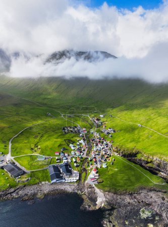 Drohnen-Ansicht des Dorfes Gjogv auf den Färöern mit bunten Häusern. Berglandschaft mit Meeresküste