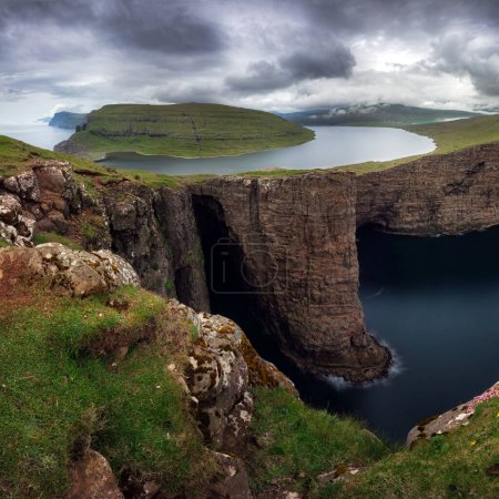 Faroe Islands landscape- Hike to the Traelanipa Slave Cliff near Leitisvatn Lake with steep drops into the ocean, Denmark. 