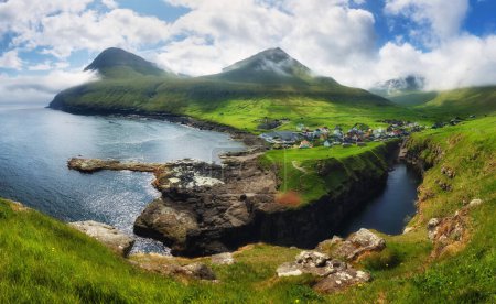 Dorf Gjogv auf den Färöern mit farbenfrohen Häusern. Berglandschaft mit Meeresküste