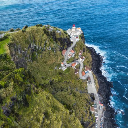 Aerial view of a curvy road leading to a lighthouse in the Azores Islands (Farol da Ponta do Arnel )