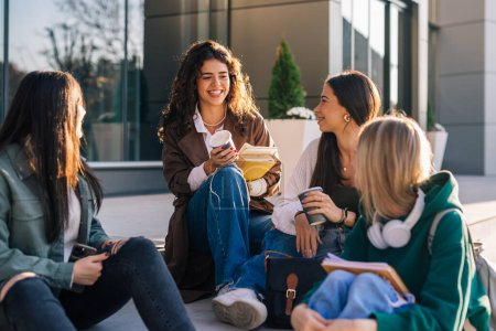 Foto de Grupo de estudiantes universitarias al aire libre en el campus hablando y sonriendo - Imagen libre de derechos
