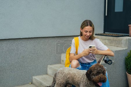 Téléchargez les photos : Fille s'assoit devant une maison avec son chien - en image libre de droit