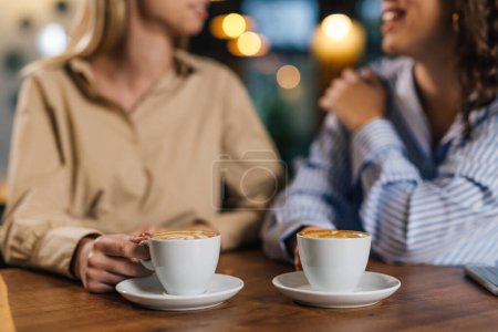 Téléchargez les photos : Deux femmes tenant des tasses de café - en image libre de droit