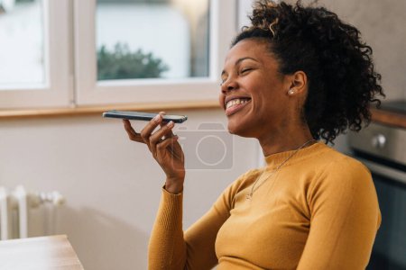 Téléchargez les photos : Vue rapprochée de la femme noire ayant une conversation drôle au téléphone - en image libre de droit