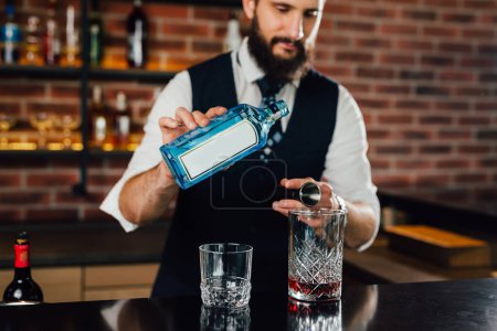 Foto de Cantinero vierte bebida alcohólica en una mezcla de cócteles - Imagen libre de derechos