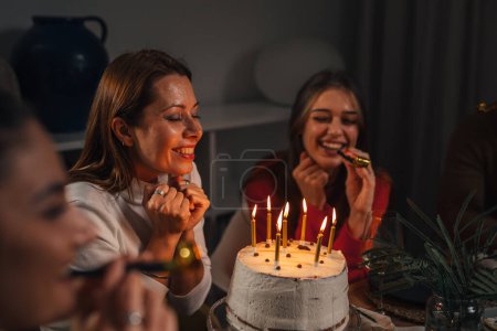 Téléchargez les photos : Femme heureuse fait un vœu pour son anniversaire entouré de ses amis - en image libre de droit