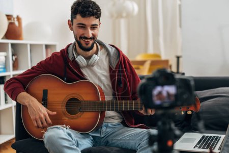 Téléchargez les photos : Un musicien s'enregistre en train de jouer de la guitare - en image libre de droit