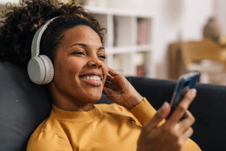 Foto de Mujer sonriente escucha música con auriculares - Imagen libre de derechos
