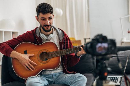 Téléchargez les photos : Jeune musicien s'enregistre à la guitare - en image libre de droit