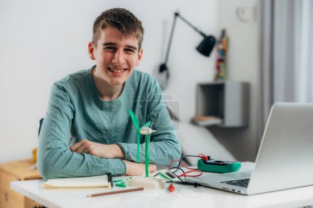 Photo for Teenage boy is proud of his wind generator model, look at the camera - Royalty Free Image