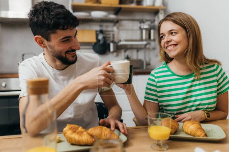 Téléchargez les photos : Jeune couple prend le petit déjeuner ensemble - en image libre de droit