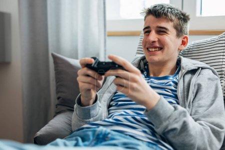 Foto de Young teenage boy enjoys playing video games - Imagen libre de derechos