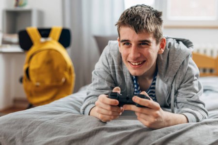 Photo for A yong boy plays video games at home - Royalty Free Image