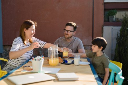 Foto de Happy family has breakfast in the backyard - Imagen libre de derechos