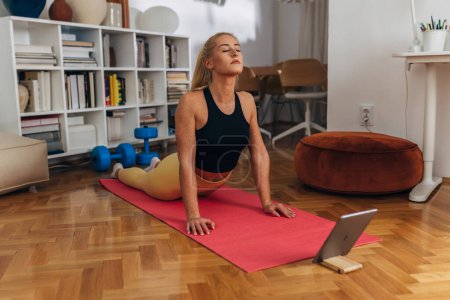 Téléchargez les photos : Jeune femme caucasienne faire du yoga à la maison - en image libre de droit