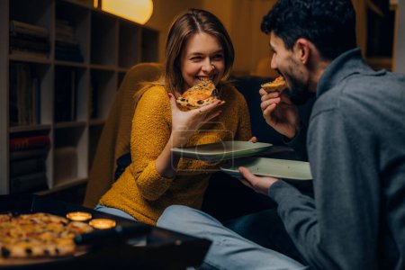Foto de Young couple eats pizza together - Imagen libre de derechos