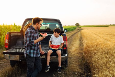 Téléchargez les photos : Père et fils assis sur le camion sur une route de campagne - en image libre de droit