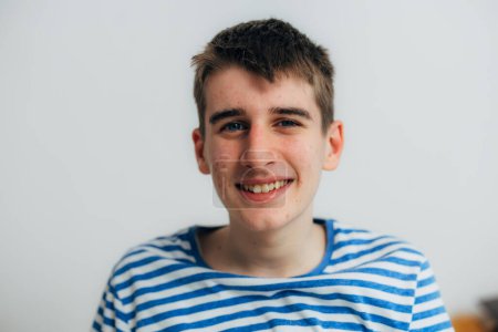 Téléchargez les photos : Portrait d'un adolescent heureux avec de l'acné sur le visage - en image libre de droit