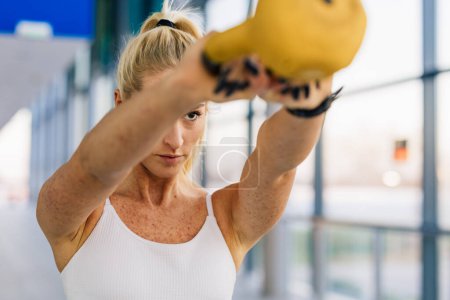 Foto de Committed Caucasian sportswoman lifts a weight - Imagen libre de derechos