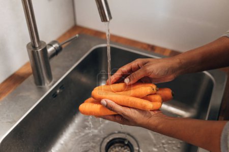 Photo for Close up view of womans hands washing carrots in the sink - Royalty Free Image