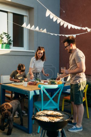 Photo for Caucasian family is preparing lunch in the backyard - Royalty Free Image
