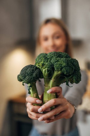 Téléchargez les photos : Woman holds broccoli in her hands - en image libre de droit