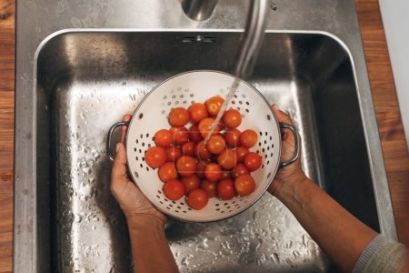 Foto de Los tomates cherry se lavan en el colador, ver desde arriba - Imagen libre de derechos