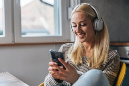 Téléchargez les photos : Une femme blonde écoute de la musique et bavarde avec un ami - en image libre de droit