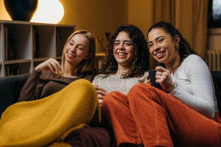 Photo for Three beautiful female friends have a movie night together - Royalty Free Image