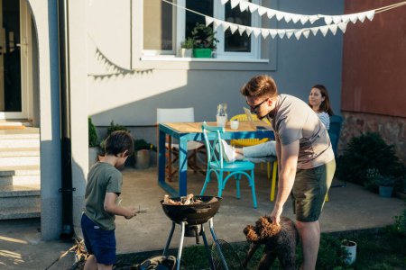 Téléchargez les photos : La famille fait un barbecue le week-end dans la cour arrière - en image libre de droit