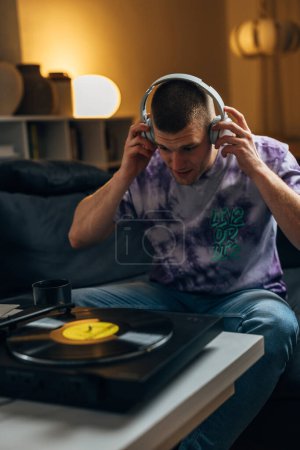 Photo for A Caucasian man puts on headset too listen to music - Royalty Free Image