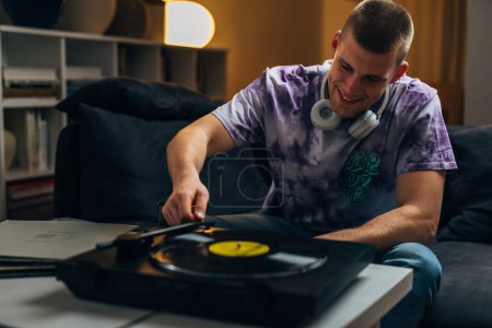 Photo for A man enjoys playing music on gramophone - Royalty Free Image