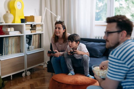 Téléchargez les photos : Mère et fils jouent au jeu vidéo ensemble à la maison - en image libre de droit