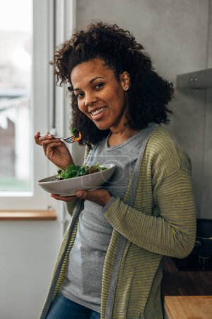 Téléchargez les photos : Une femme biraciale heureuse aime sa salade - en image libre de droit