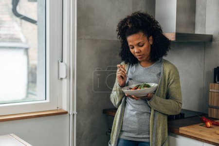 Foto de La mujer multirracial está a dieta. Una mujer come una ensalada. - Imagen libre de derechos