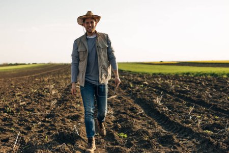 Foto de Un granjero caucásico está dando un paseo por el campo. - Imagen libre de derechos