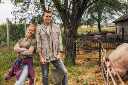 Photo for Front view of a young Caucasian couple living a domestic lifestyle on a farm. - Royalty Free Image