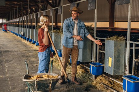 Téléchargez les photos : Fermier à la ferme animale montre le décrochage o la nouvelle fille. - en image libre de droit