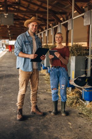Téléchargez les photos : Deux jeunes gens attrayants qui travaillent à la ferme dans une campagne - en image libre de droit