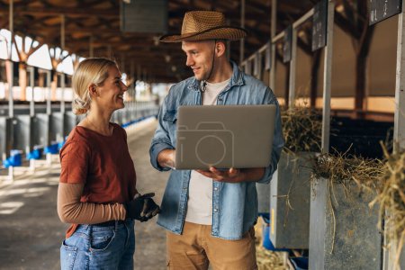 Téléchargez les photos : Femme et homme parlent et se lient tout en travaillant à la ferme animale. - en image libre de droit