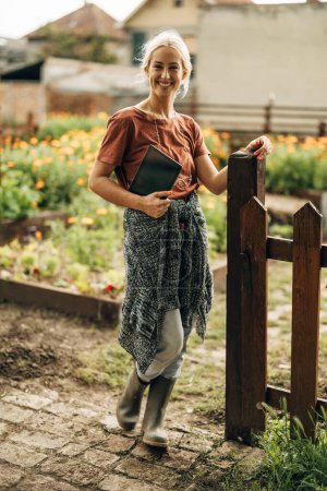 Foto de Vista frontal de una jardinera de pie frente a su jardín ecológico. - Imagen libre de derechos