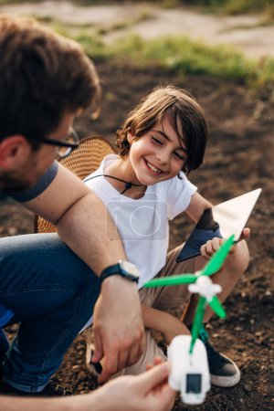 Téléchargez les photos : Vue rapprochée d'un jeune garçon heureux jouant avec son père dans le jardin. - en image libre de droit