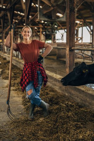 Téléchargez les photos : Vue de face de la belle femme travaillant à la ferme animalière. - en image libre de droit