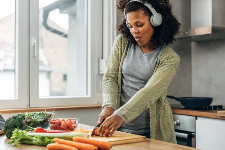 Foto de Una mujer está preparando una comida vegana con verduras orgánicas. - Imagen libre de derechos