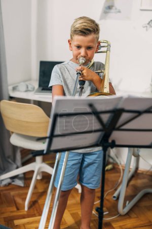 Foto de Un chico caucásico practica su instrumento musical. - Imagen libre de derechos