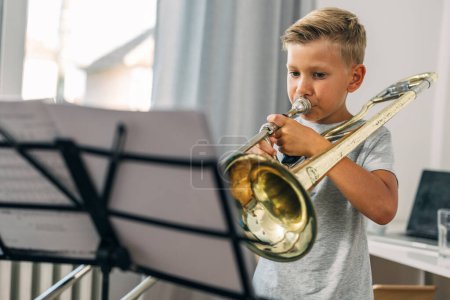 A young boy playing trombone.