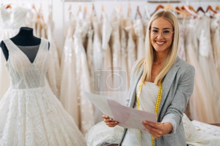 Photo for A beautiful blonde woman works in a bridal store. - Royalty Free Image